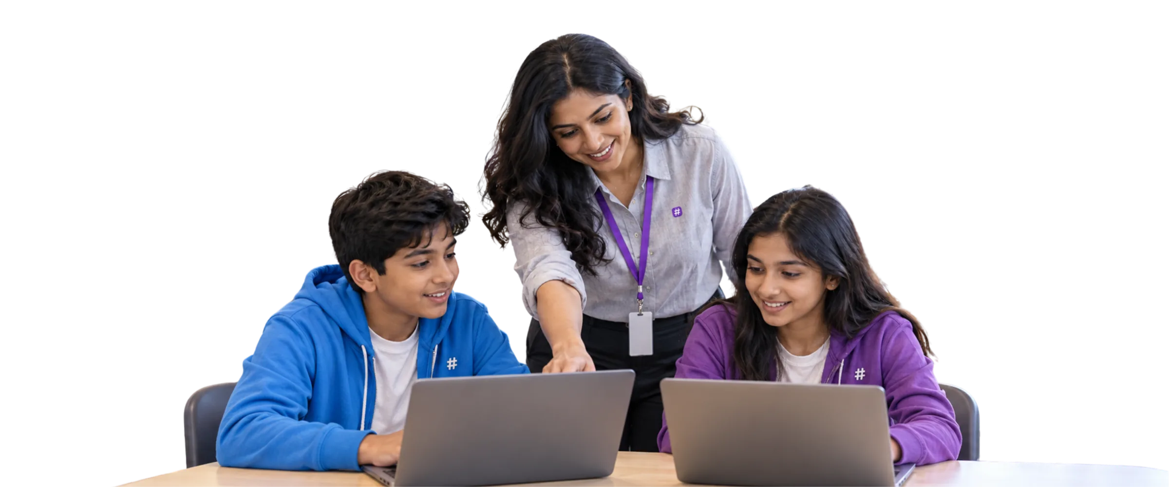 Teacher helping two students at their laptops